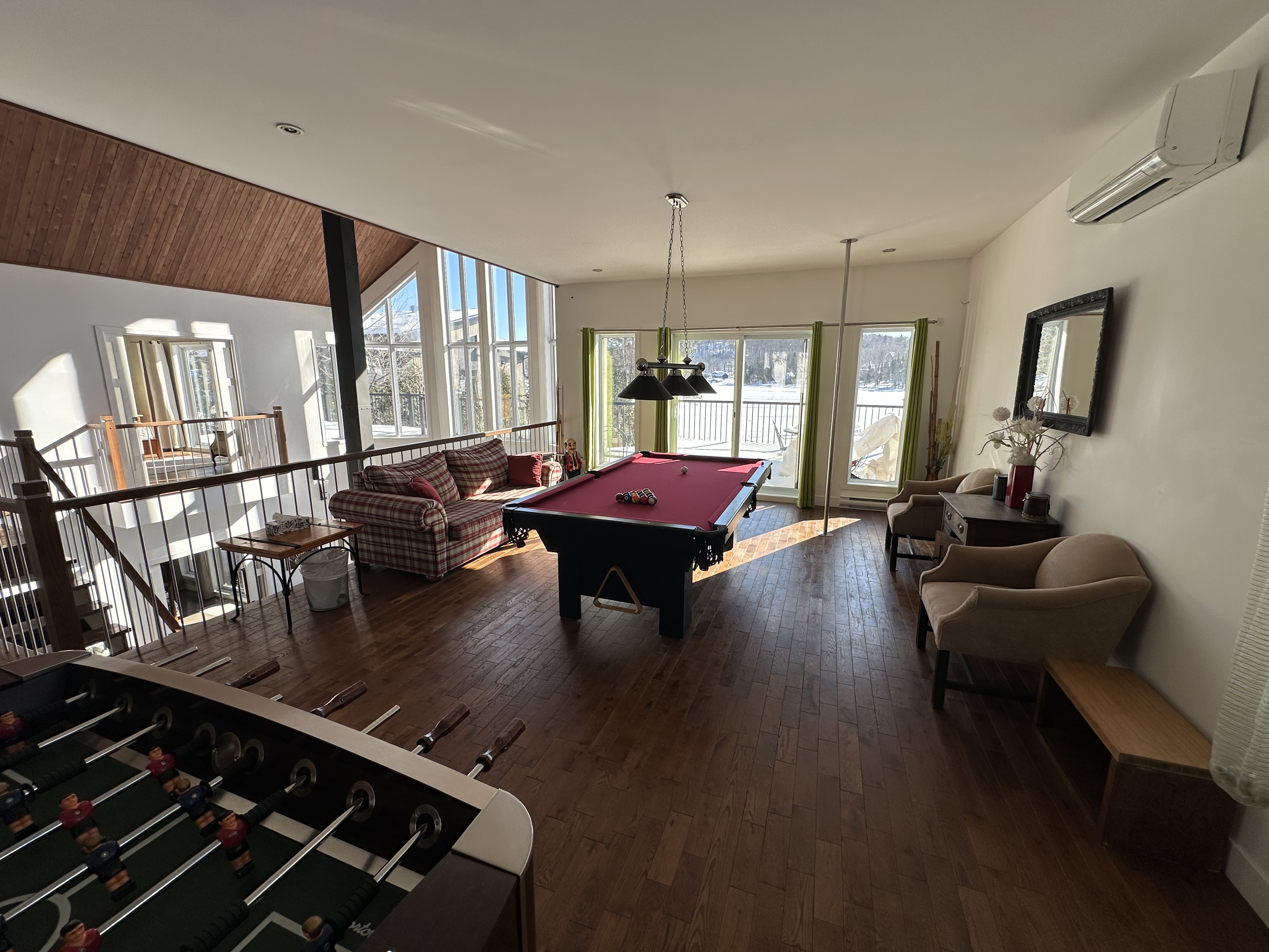 Salle de jeu à l'étage avec table de billard et vue sur le lac